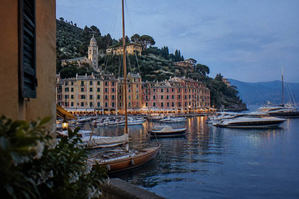A wooden sailing boat and modern yachts moored during a boat show in a large harbour