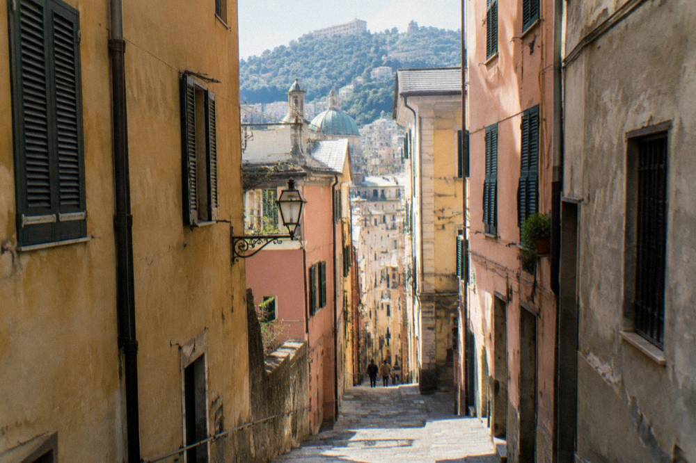 Narrow medieval alley in an Italian old town with tall stone buildings on both sides