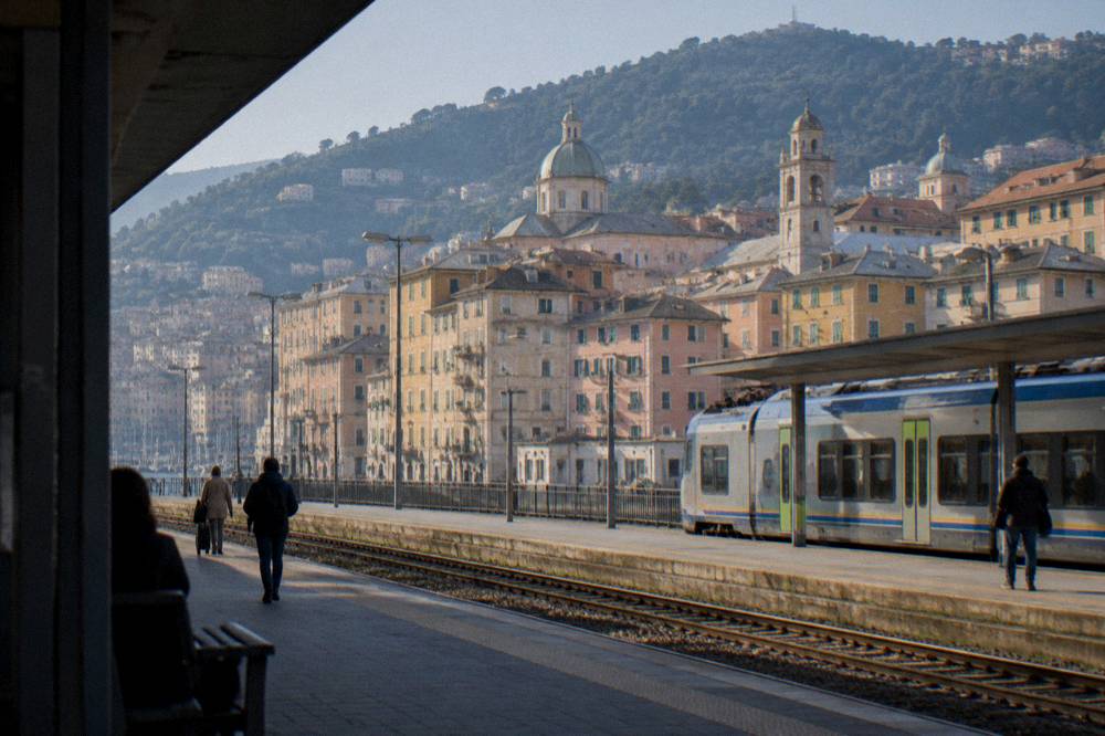 Station platform with a regional train and departure board in Genoa