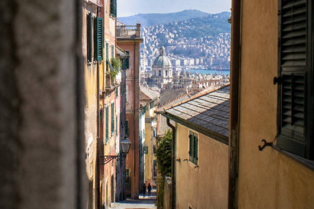 Narrow medieval alley in the old town of Genoa with tall coloured buildings