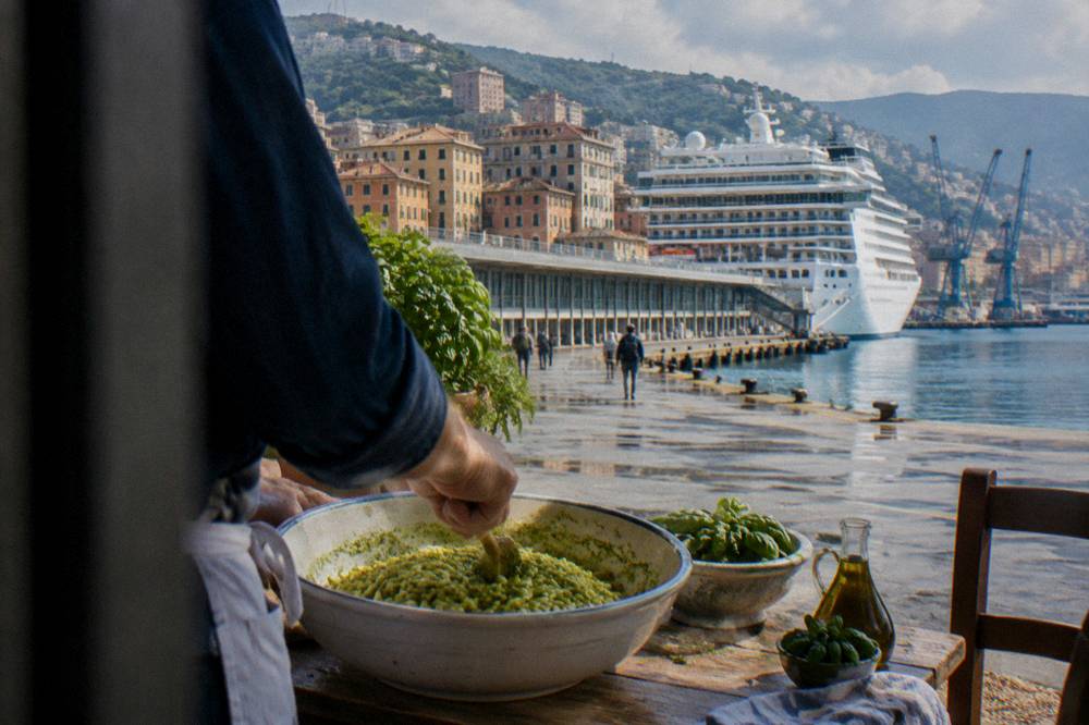 Fresh green pesto being stirred into a bowl of trofie pasta