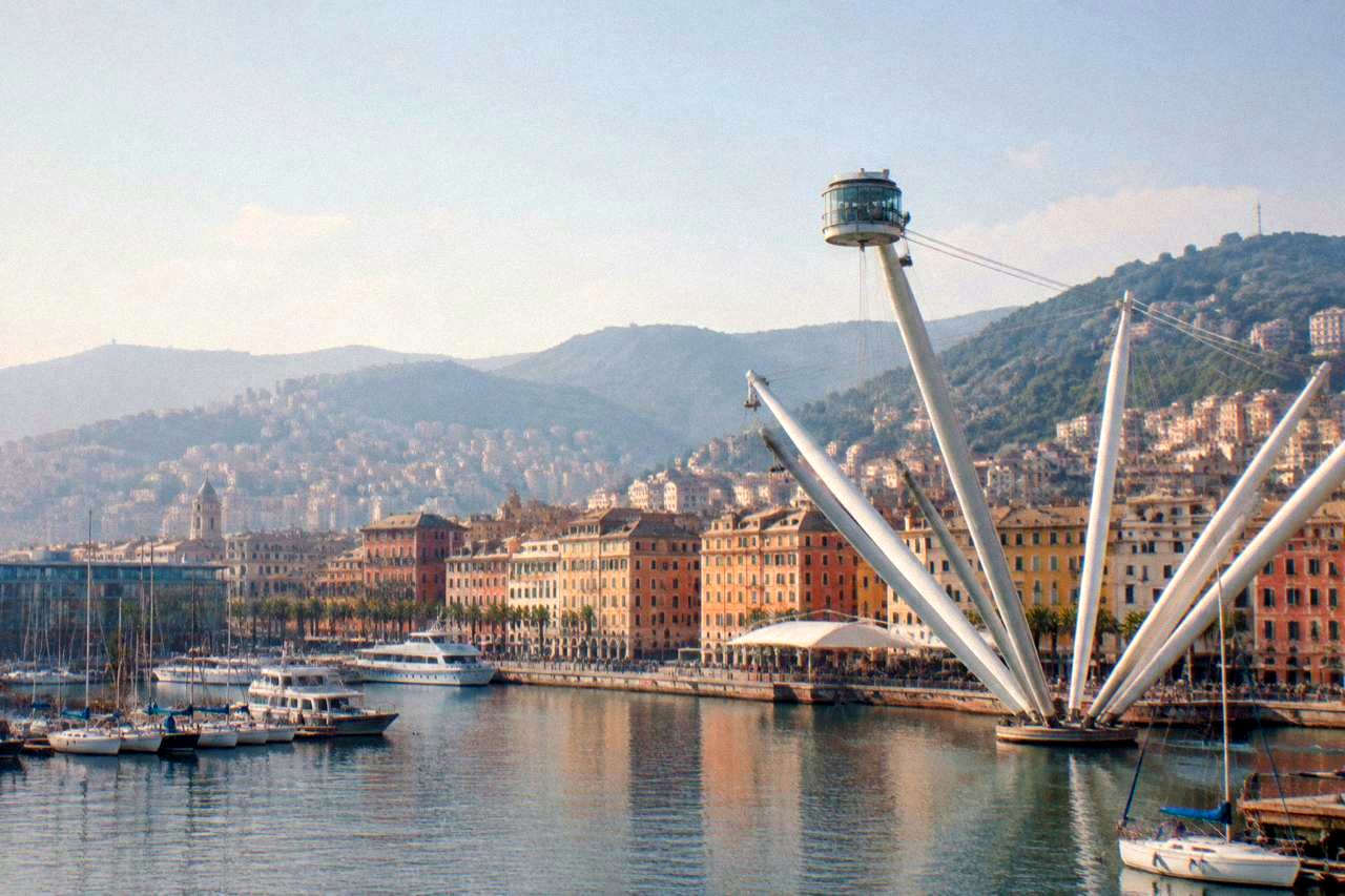 The old harbour of Genoa with the Bigo lift, boats and the hills behind