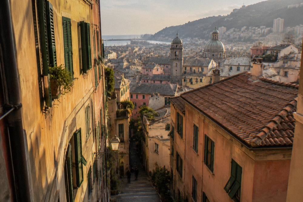 Narrow alley in the medieval old town of Genoa with tall painted buildings