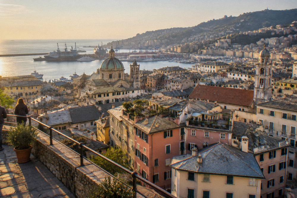 Panoramic terrace overlooking the rooftops and harbour of Genoa at golden hour