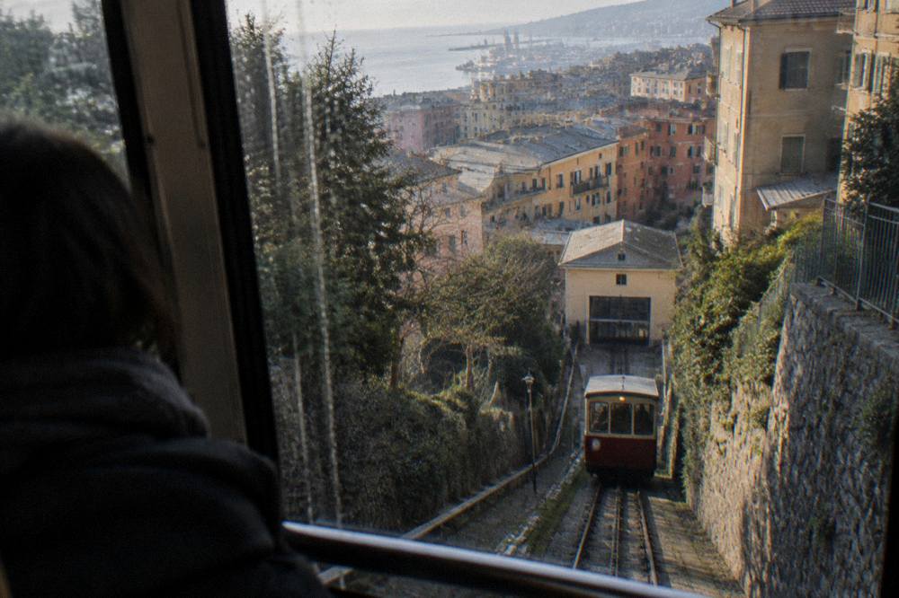 Funicular carriage interior with rain-streaked window and city lights beyond