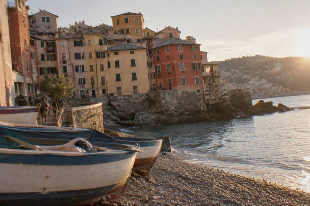 Boats moored in a small Ligurian harbour with pastel houses behind
