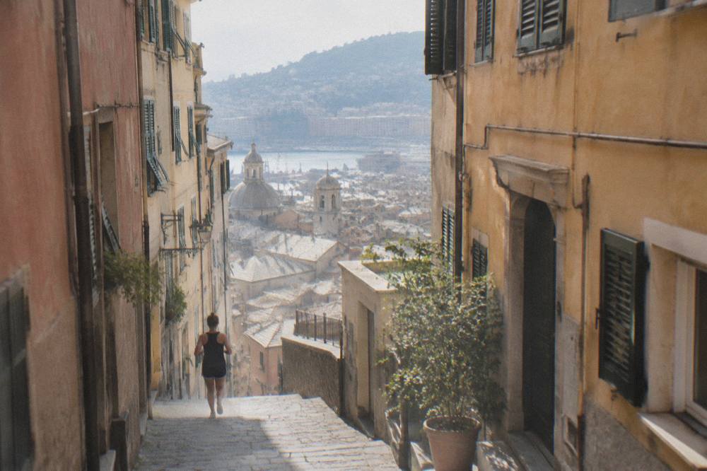 Narrow alley in the medieval old town of Genoa with tall painted buildings