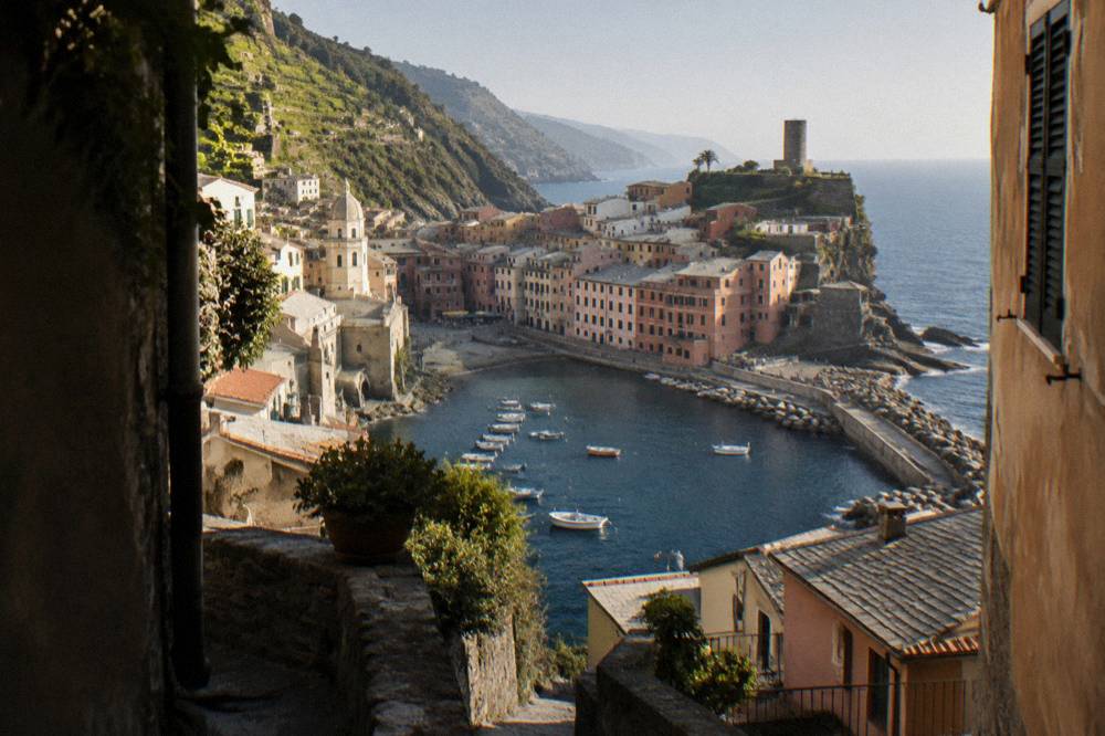 A small pastel village clustered around a harbour with boats at rest