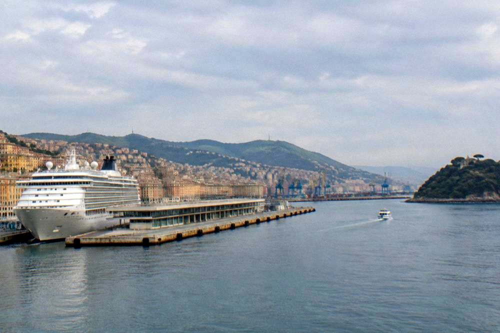 Small boat approaching a wooded headland on the Ligurian coast