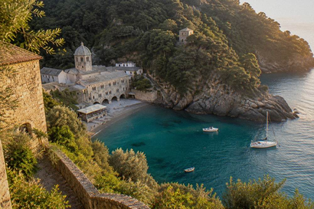 A stone abbey and small beach in a wooded cove at San Fruttuoso