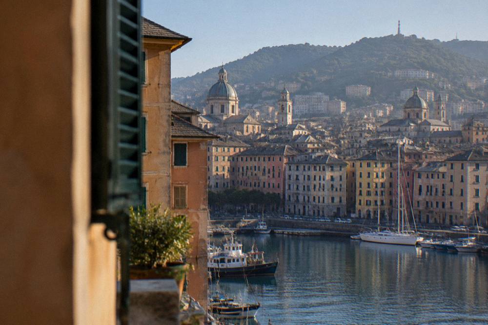 The Genoa skyline seen from the water with hills rising behind the city